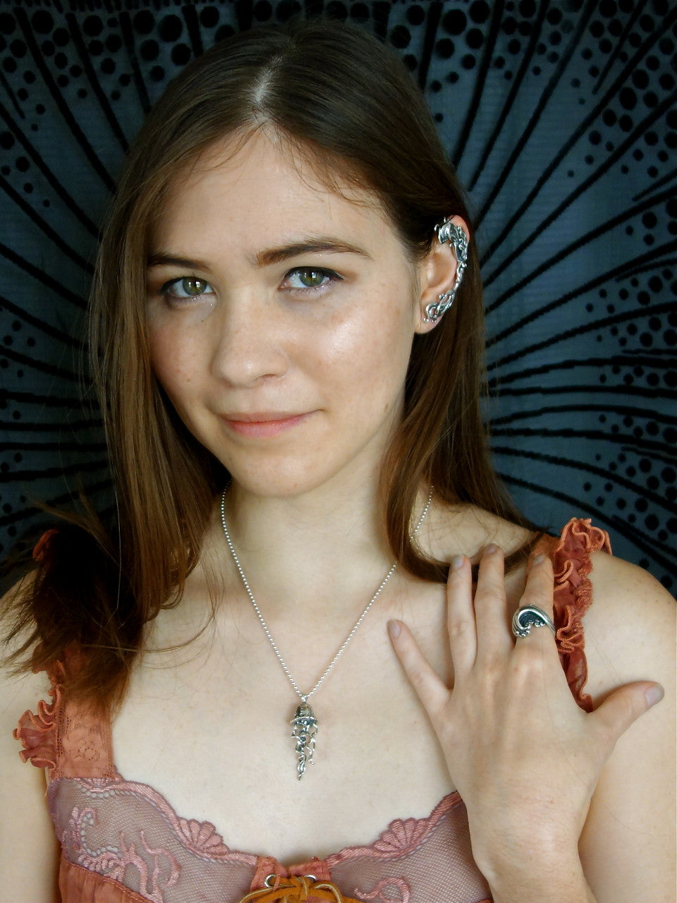 Teresa is wearing the sterling silver Jelly Fish charm, Mermaid Ear Wrap, and Maverick's Wave ring