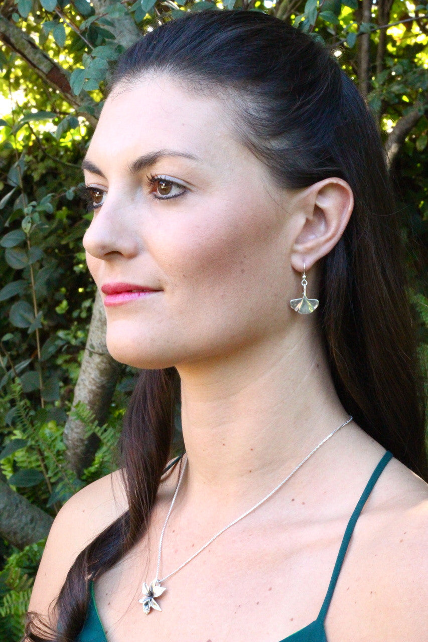 Model is wearing Gingko Leaf Earrings & Orchid Charm