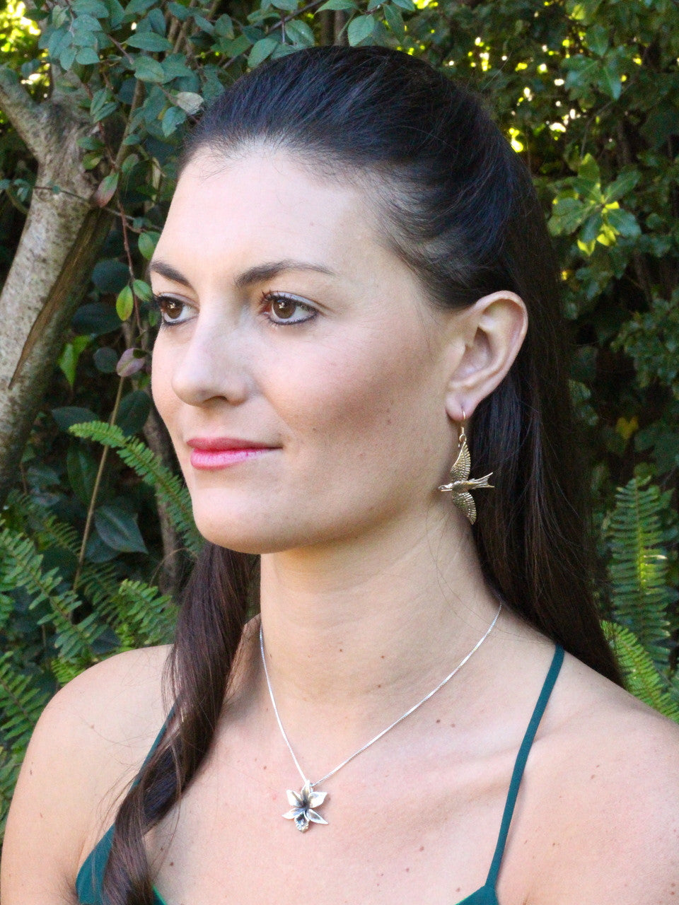 Model is wearing bronze Mocking Jay Earrings & Silver Orchid Charm