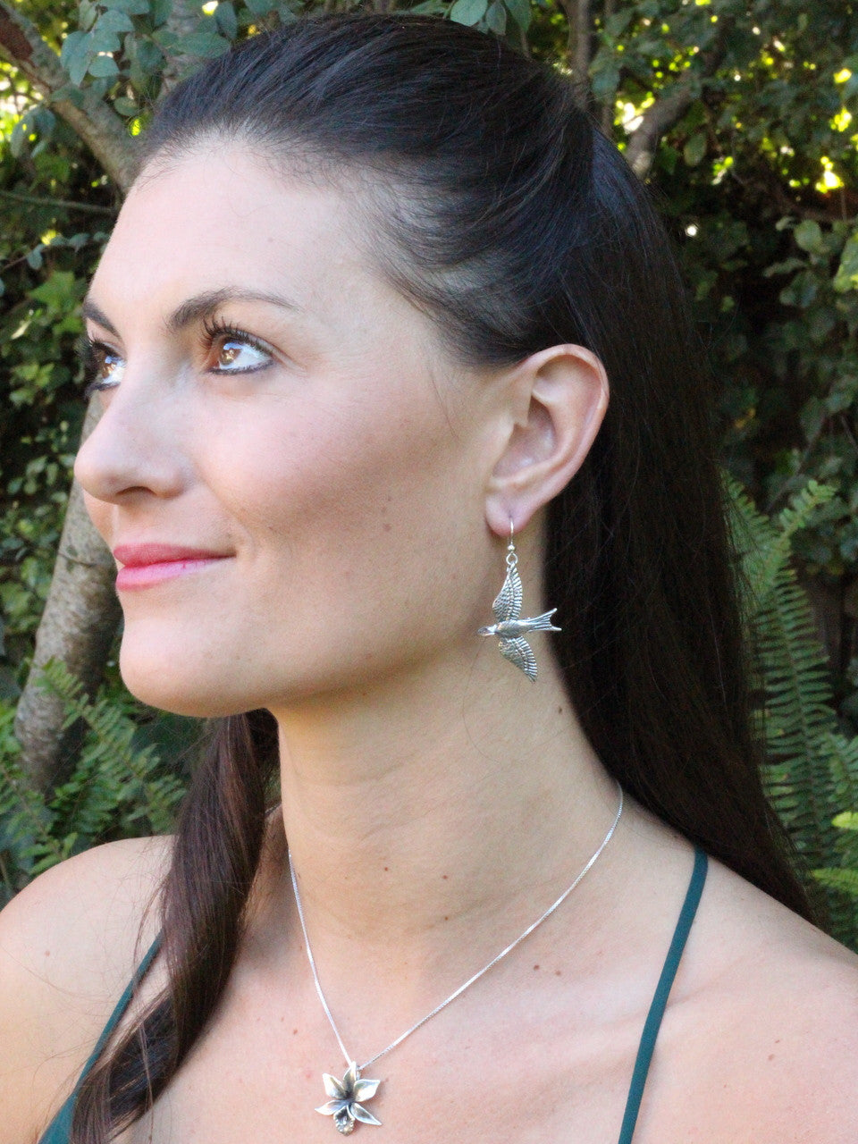 Model is wearing Mocking Jay Earrings & Orchid Charm