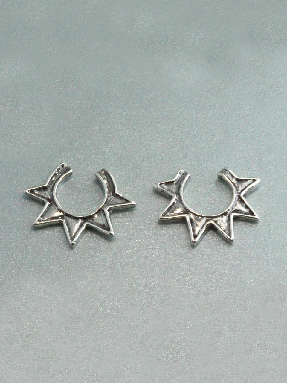The two separate Ninja Star Ear Cuffs, one with six points, one with five points.